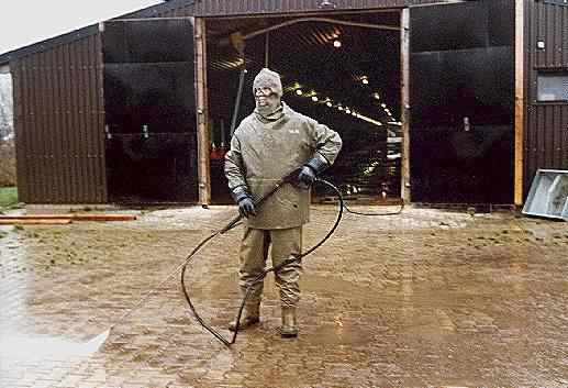 ein Reiniger vor einem Stall