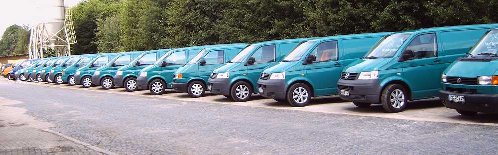 Eine lange Reihe von grünen VW-Bussen